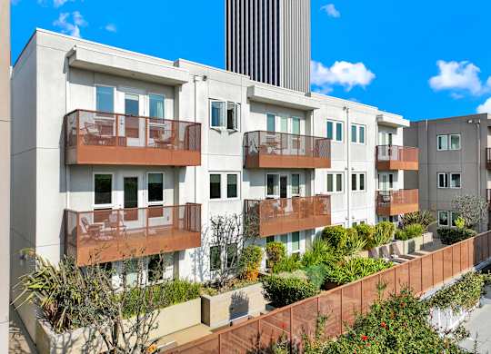 A row of modern apartment buildings with balconies and plants in front at The Urbanpolitan, California 90036