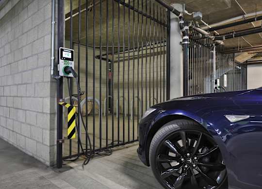 A car is parked in a garage next to a gate with a digital display at The Urbanpolitan, Los Angeles