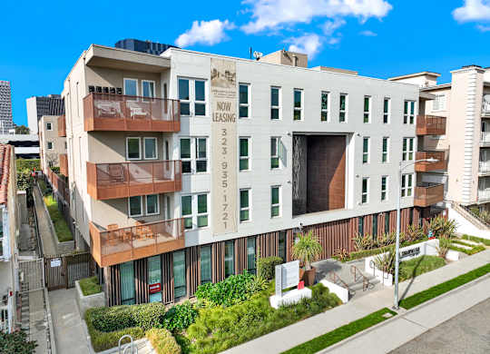 A modern apartment building with a sign at The Urbanpolitan, Los Angeles, CA