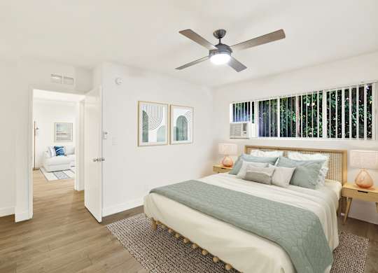 A bedroom with a bed, a ceiling fan, and a window with blinds at Wooster Encore Apartments, Los Angeles, 90035