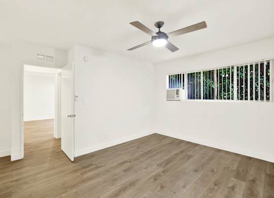 A room with a ceiling fan and wooden flooring at Wooster Encore Apartments, California