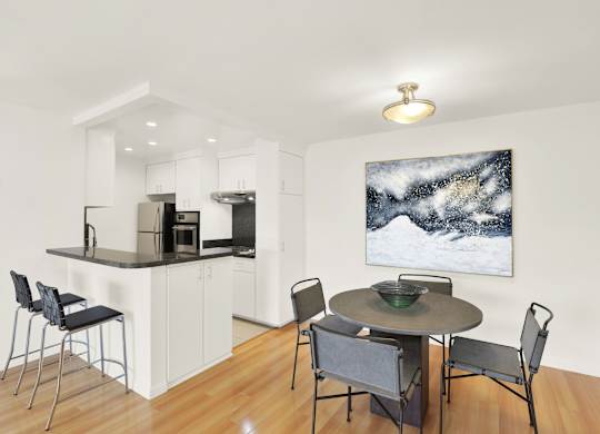 A modern kitchen with a dining table and chairs at Wooster Encore Apartments, Los Angeles, 90035