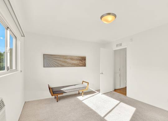 A room with a bench and a painting on the wall at Wooster Encore Apartments, Los Angeles, CA 90035