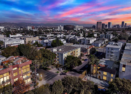 A cityscape with buildings and a street in the foreground at Wooster Encore Apartments, Los Angeles
