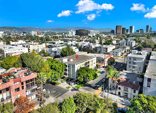 A cityscape with buildings, trees, and a clear sky at Wooster Encore Apartments, Los Angeles, 90035