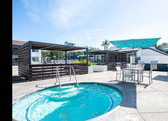 A pool with a ladder and a sun shade.