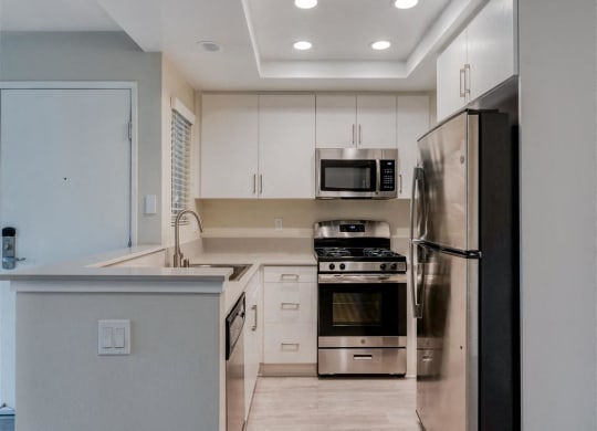a kitchen with white cabinets and stainless steel appliances  at Laguna Gardens Apts., Laguna Niguel, CA, 92677