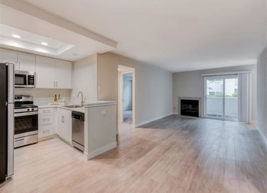 an empty kitchen and living room with a fireplace  at Laguna Gardens Apts., California, 92677