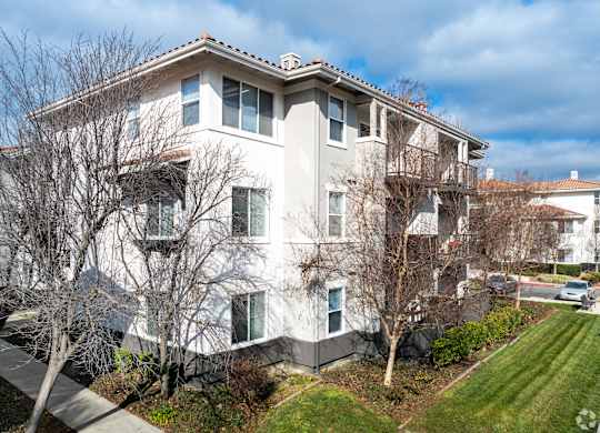 A large white building with a red roof and a tree in front at Cornerstone at Gale Ranch Apartments, San Ramon, CA, 94582