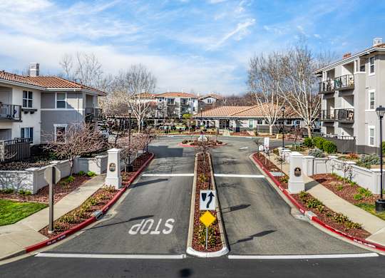A street view of a residential area with a stop sign at the end of the road at Cornerstone at Gale Ranch Apartments, San Ramon, California