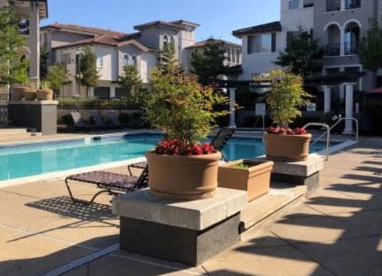 a swimming pool with a chaise lounge chair and potted plants  at Falcon Bridge at Gale Ranch, California