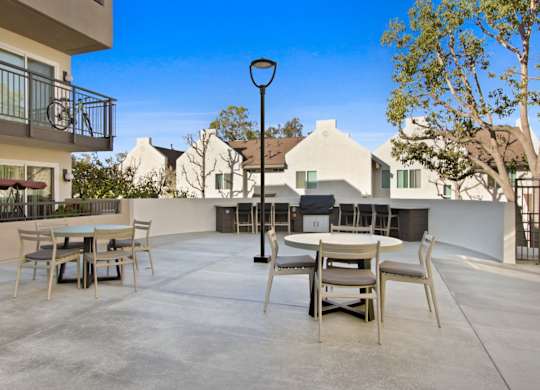 A patio with a table and chairs is surrounded by houses.