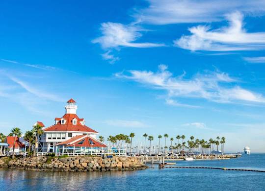 A lighthouse stands on a pier overlooking a calm sea.