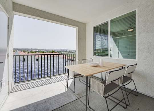 A balcony with a table and chairs overlooking a pool at Montecito at Carlsbad, Carlsbad, CA 92010