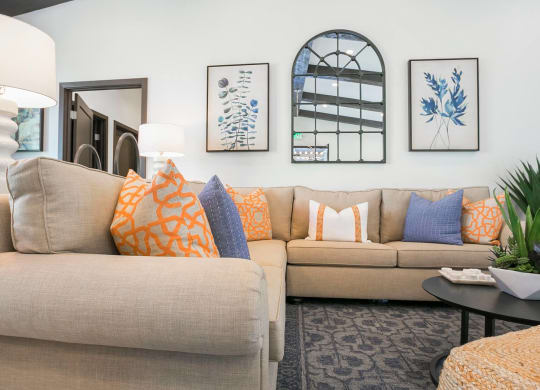a living room with a tan couch and blue and orange pillows at Arroyo Villa Apartments, California, 91320