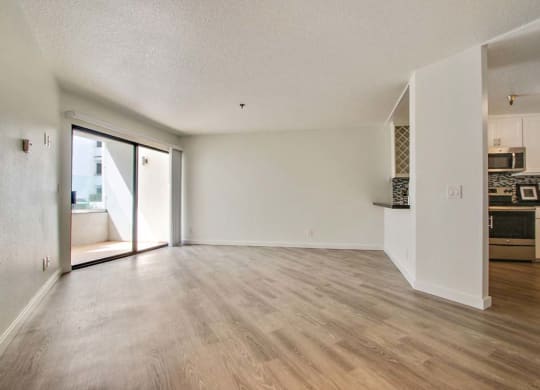 an empty living room with a kitchen in the background  at Masselin Park West, Los Angeles, 90036