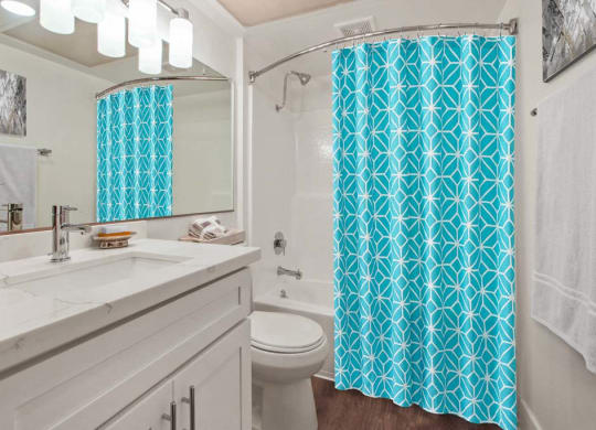 a bathroom with a white sink and a blue shower curtain  at Masselin Park West, Los Angeles, 90036 