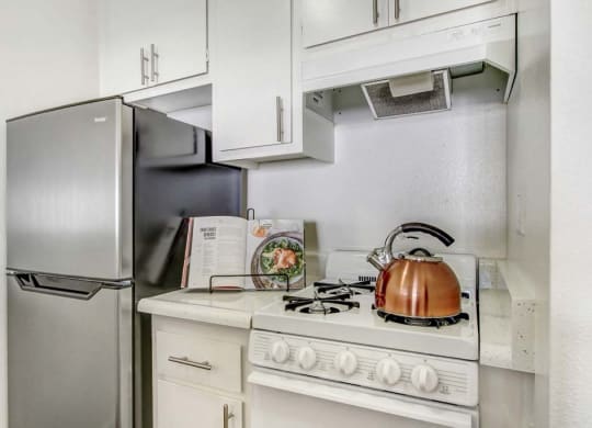 a kitchen with a stove top oven next to a refrigerator  at Sherway Villa, Reseda, California