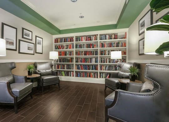a living room filled with furniture and a large book shelf  at Ventana Senior Apartments, California, 91326