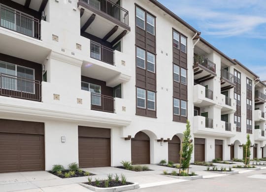a white and brown apartment building with brown garage doors at Deer Creek Apartments, San Ramon, 94582