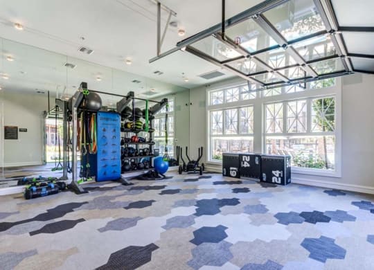 a large room with a lot of windows and a gym equipment at The Vineyards Apartments, California