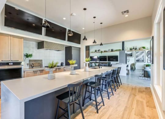 a kitchen with a long counter and chairs at The Vineyards Apartments, California, 91326
