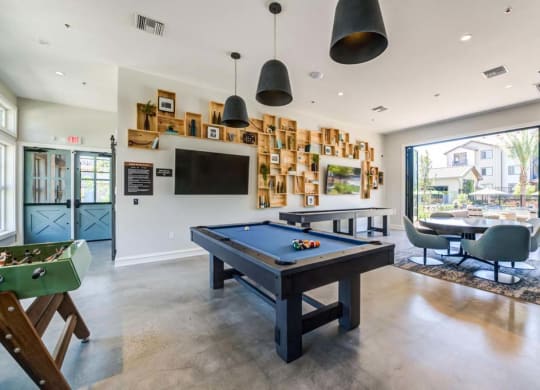 a games room with a pool table and a television at The Vineyards Apartments, Porter Ranch, 91326