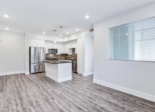 a kitchen with a stove top oven next to a refrigerator at The Vineyards Apartments, California