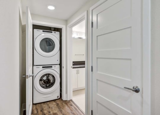 a small laundry room with a washer and dryer at The Vineyards Apartments, Porter Ranch, CA