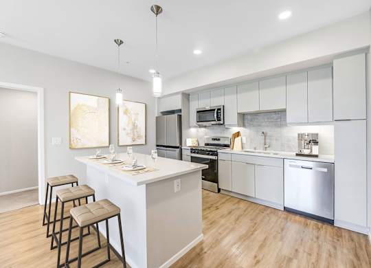 A modern kitchen with a bar area and stools.