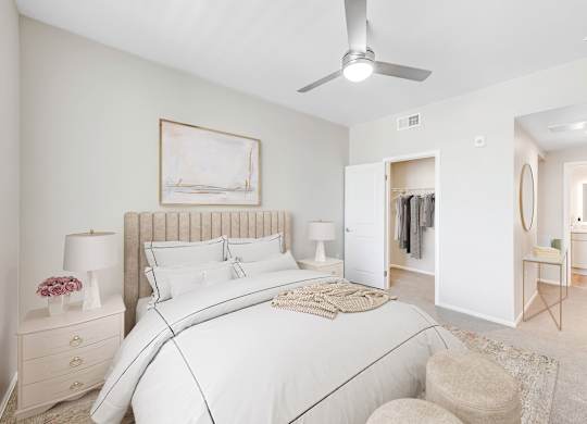 A bedroom with a large bed, a ceiling fan, and a painting on the wall.
