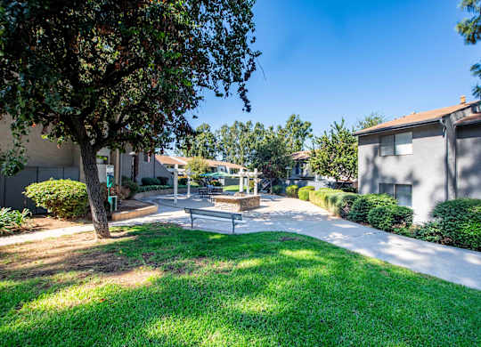 A sunny day in a residential area with a park and houses.