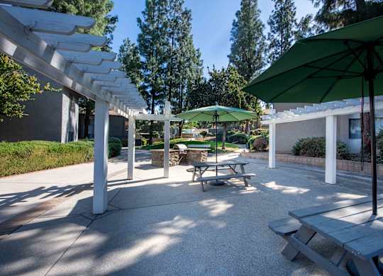 A patio with a table and chairs under a green umbrella.