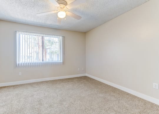 a bedroom with a ceiling fan and a window  at Redlands Park Apts, Redlands, 92373