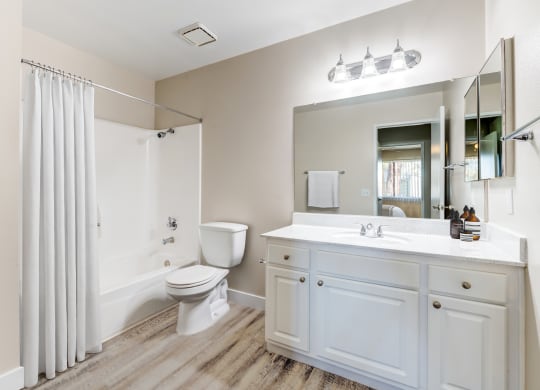 a bathroom with a shower toilet and sink at Redlands Park Apts, Redlands, CA, 92373