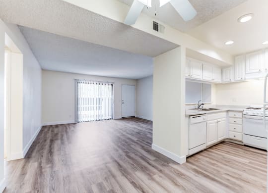 an empty kitchen and living room with a ceiling fan  at Redlands Park Apts, California, 92373