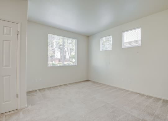 an empty bedroom with a door and three windows  at Seville at Gale Ranch, San Ramon