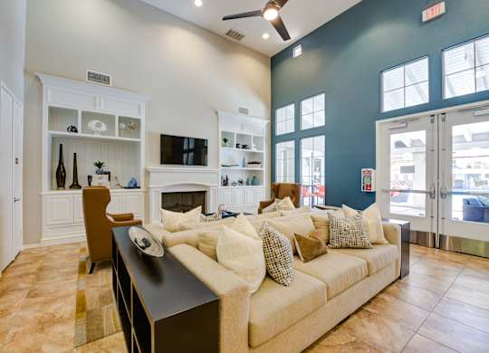 Community lounge with a couch, a fireplace, and a television at Sonoma at Porter Ranch, CA, 91326