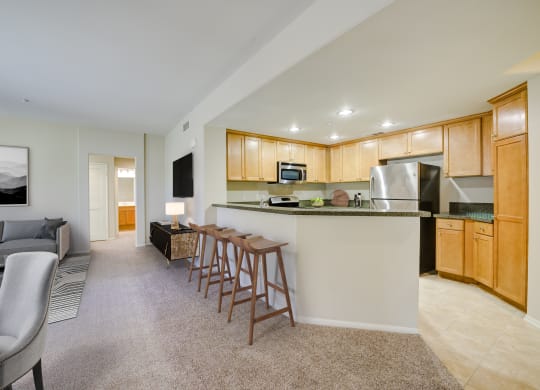 a kitchen and living room with wood cabinetry  at Sonoma at Porter Ranch, Porter Ranch, California