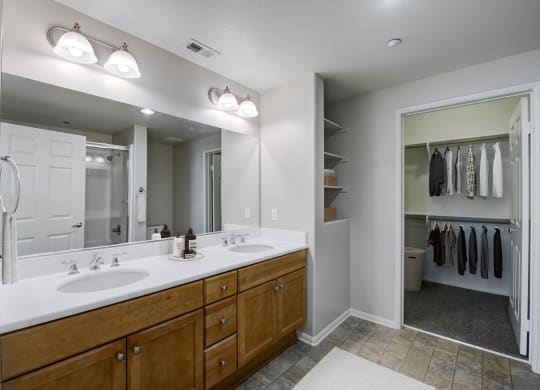 a bathroom with a large mirror and two sinks  at Sonoma at Porter Ranch, Porter Ranch, CA