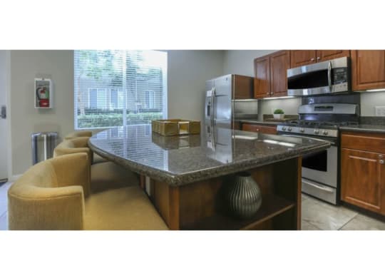 a kitchen with a counter top and a stove top oven  at Tesoro Senior Apartments, California, 91326