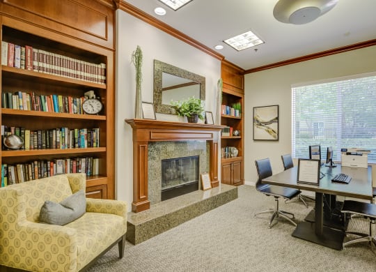 a room with a fireplace and a table and chairs  at Tesoro Senior Apartments, Porter Ranch, California