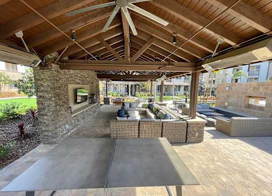 Outdoor patio with seating a television and games at The Vineyards Apartments, California, 91326