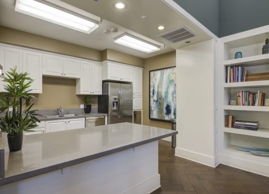 a kitchen with white cabinets and a large island  at Ventana Senior Apartments, Northridge