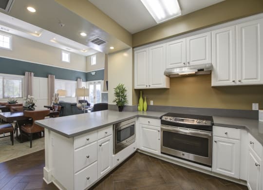 a kitchen with white cabinets and stainless steel appliances  at Ventana Senior Apartments, California, 91326