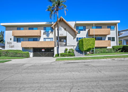 a large white building with a palm tree in front of it at Palm Capri Apartments, Burbank, CA, 91501