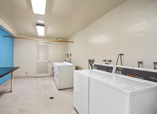a laundry room with two washes and a dryer in it at Palm Capri Apartments, Burbank, 91501