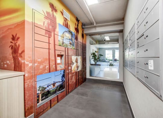 a hallway with a mural on the wall and lockers on the right at Toluca Court, Toluca Lake, CA