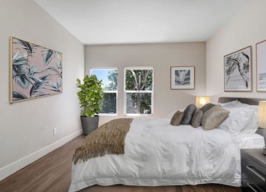 a bedroom with a large bed and three windows at Toluca Court, Toluca Lake, CA