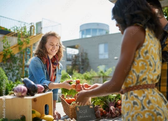 two women buying fruits and vegetables at an outdoor market at Darlington Apartments, Los Angeles, CA